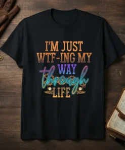 Black t-shirt with the quote "I'm Just Wtf-ing My Way Through Life" in colorful, distressed typography, featuring steampunk-inspired gears and