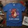 Blue t-shirt with "I'm Just A Chicken" text, featuring a rooster wearing heart sunglasses and surrounded by hearts