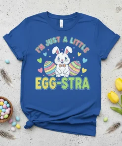 I'm Just A Little Egg-stra text with a cute Easter bunny and colorful eggs graphic on a blue t-shirt
