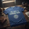 Blue t-shirt with white text "I'm Just A Random Dude" and a compass graphic