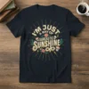 I'm Just a Ray of Sarcastic Sunshine text design with skulls, flowers, and cacti on a navy t-shirt
