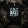 I'm Just The Bass Bass Player quote with electric guitar graphic and equalizer bars on a black t-shirt