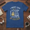 Blue t-shirt with white and gold text that reads "I Might Look Like I'm Listening To You But In My