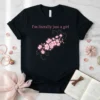 T-shirt with pink text "I'm literally just a girl" above a cluster of pink cherry blossoms and gold accents
