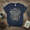 Navy blue t-shirt with "I'm My Mother-In-Law's In-Lavits Favorite Child" text in decorative gold and cream font