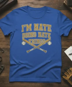 Blue t-shirt with yellow text "I'M NATE DOING NATE THINGS" and crossed baseball bats with baseballs