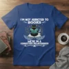 T-shirt with text "I'm Not Addicted To Books We're In A Committed Relationship" featuring a black cat reading a book