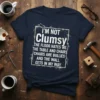 T-shirt with the quote "I'm Not Clumsy The Floor Hates Me" in white distressed typography