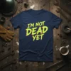 I'm Not Dead Yet quote in distressed yellow and red font on a navy t-shirt