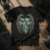 Black t-shirt with "I'm Not Dead Yet!" text above a detailed gothic heart with gears and wings