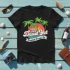 Black t-shirt with "I'm Not Dead Yet Tropical Escape" text, palm trees, and sunset graphic
