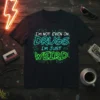 Black t-shirt with neon green and blue text reading "I'm Not Even On Drugs I'm Just Weird" with circuit board