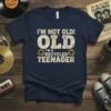 Navy t-shirt with "I'm Not Old! OLD I'M A RECYCLED TEENAGER" text in distressed white and yellow, featuring recycling symbols