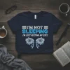 Navy t-shirt with "I'M NOT SLEEPING I'M JUST RESTING MY EYES" text and stylized eyes graphic