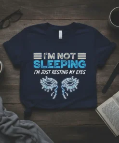 Navy t-shirt with "I'M NOT SLEEPING I'M JUST RESTING MY EYES" text and stylized eyes graphic