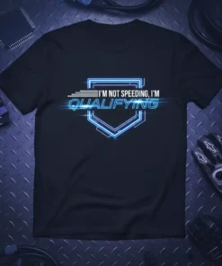 I'm Not Speeding I'm Qualifying text in neon blue outline on a black t-shirt, featuring a futuristic shield graphic