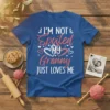 I'm Not Spoiled My Granny Just Loves Me text on a blue t-shirt with heart graphics, white and pink font