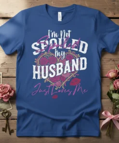 I'm Not Spoiled my HUSBAND Just Loves Me quote with floral heart and lips graphic on a blue t-shirt
