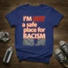 Bold typography reads "I'M NOT a safe place for RACISM" with cracked brick wall and chains graphic on a blue