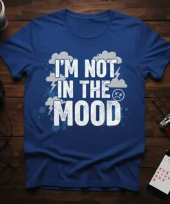 I'm Not In The Mood text design with distressed white font, clouds, and lightning bolts on a royal blue t-shirt