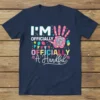 Fifth birthday t-shirt design with text "I'm Officially Officially A Handful" and a colorful handprint with the number 5