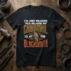 Black t-shirt with white text "I'M ONLY WEARING THIS BECAUSE MY" above "CHAINMAIL" graphic with helmet, and below "IS AT