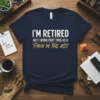 Navy t-shirt with white and gold text that reads "I'm Retired But I Work Part Time As A Pain In