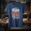T-shirt with the text "I'm Rita Doing Rita Things" in distressed white and pink lettering, featuring gear graphics