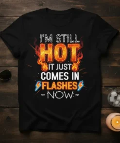 I'm Still Hot It Just Comes In Flashes Now text design with fiery graphics on a black t-shirt