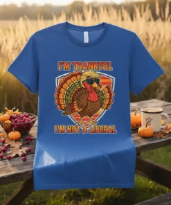 Thanksgiving turkey wearing sunglasses and a blonde wig, with text "I'm Thankful I'm Not A Liberal" on a blue t-shirt