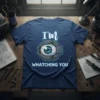 T-shirt with "I'm Whatching You" text and a robotic eye graphic, presented on a dark blue tee