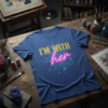 Blue t-shirt with "I'M WITH her" text in gold and neon pink, featuring a circuit board design