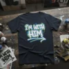 Graffiti-style "I'm With Him" text design with a blue and yellow arrow on a navy t-shirt