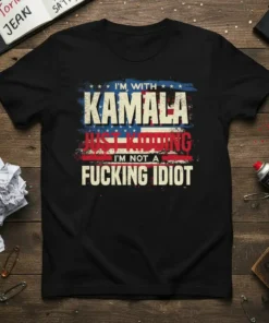 Black t-shirt with bold white and red text: "I'm With Kamala Just Kidding I'm Not A Fucking Idiot," featuring American