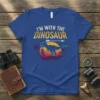 Retro "I'm With The Dinosaur" t-shirt design featuring a T-Rex silhouette, palm trees, and a sunset graphic