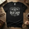 I'm With The Old Lady T-Shirt featuring bold white text and a decorative arrow design, perfect for couples