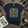 I'm a Boy! I Just Have Better Hair Than You quote on a dark t-shirt, featuring ornate gold and white