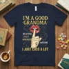 Navy t-shirt with gold glitter text: "I'M A GOOD GRANDMA BEAUTIFUL CRAZY GENEROUS AWESOME I JUST CUSS A LOT" featuring