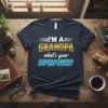 I'M A GRANDPA what's your SUPERPOWER? text design on a navy t-shirt. Features gold and blue lettering