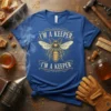 Blue t-shirt with gold text "I'm A Keeper I'm A Keeper" and a central bee graphic