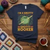 T-shirt design with text "I'm A Knotty Knotty Hooker" featuring a green ball of yarn and crochet hooks