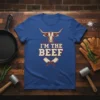 Blue t-shirt with "I'm The Beef" text, a bull's head graphic, and crossed butcher knives