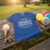 Blue t-shirt with white distressed text that reads "I'm the Favorite Granddaughter" with decorative stars and swirls