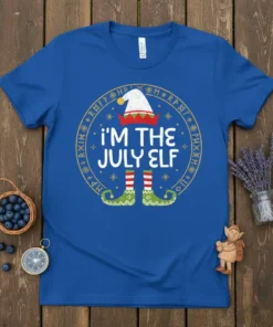 Royal blue t-shirt with "I'm The July Elf" text, elf hat, striped socks, and green elf shoes, surrounded by runes