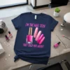 T-shirt with pink text "I'm the Nail Tech They Told You About" and graphics of nail polish bottle and nails