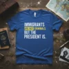 Royal blue t-shirt with bold white text: "IMMIGRANTS ARE NOT CRIMINALS." with yellow highlight on "ARE NOT CRIMINALS.", and below