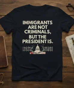 T-shirt with text "Immigrants Are Not Criminals, But The President Is" and a graphic of the US Capitol behind barbed