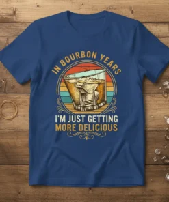 Vintage style t-shirt with text "In Bourbon Years I'm Just Getting More Delicious" and a glass of whiskey graphic