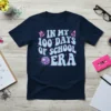 Navy blue t-shirt with "In My 100 Days Of School Era" text in light blue and pink, with butterflies and