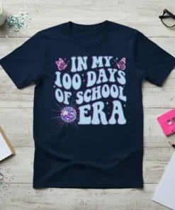 Navy blue t-shirt with "In My 100 Days Of School Era" text in light blue and pink, with butterflies and